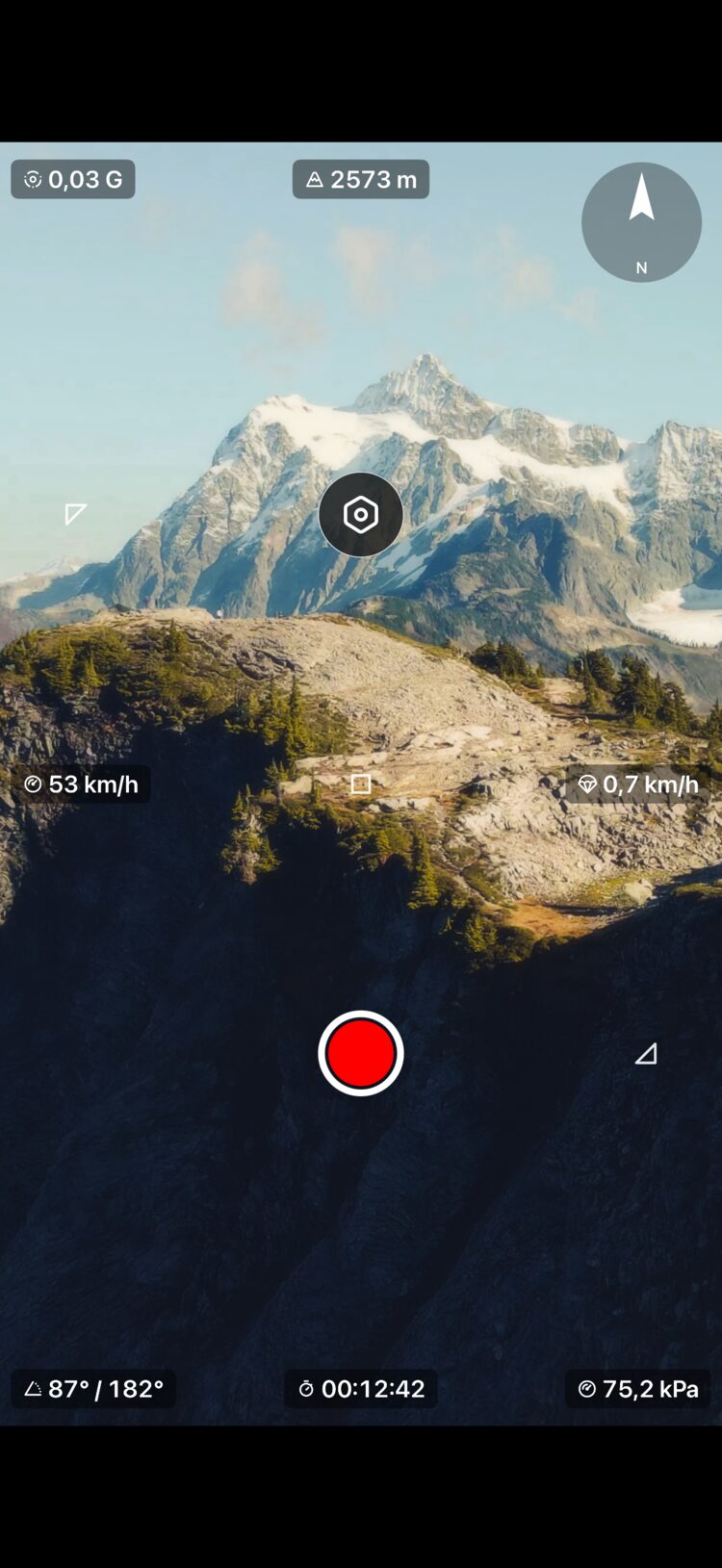 Recording with altitude, speed, compass, G-force, inclinometer, pressure, and elapsed time overlays on a mountain landscape